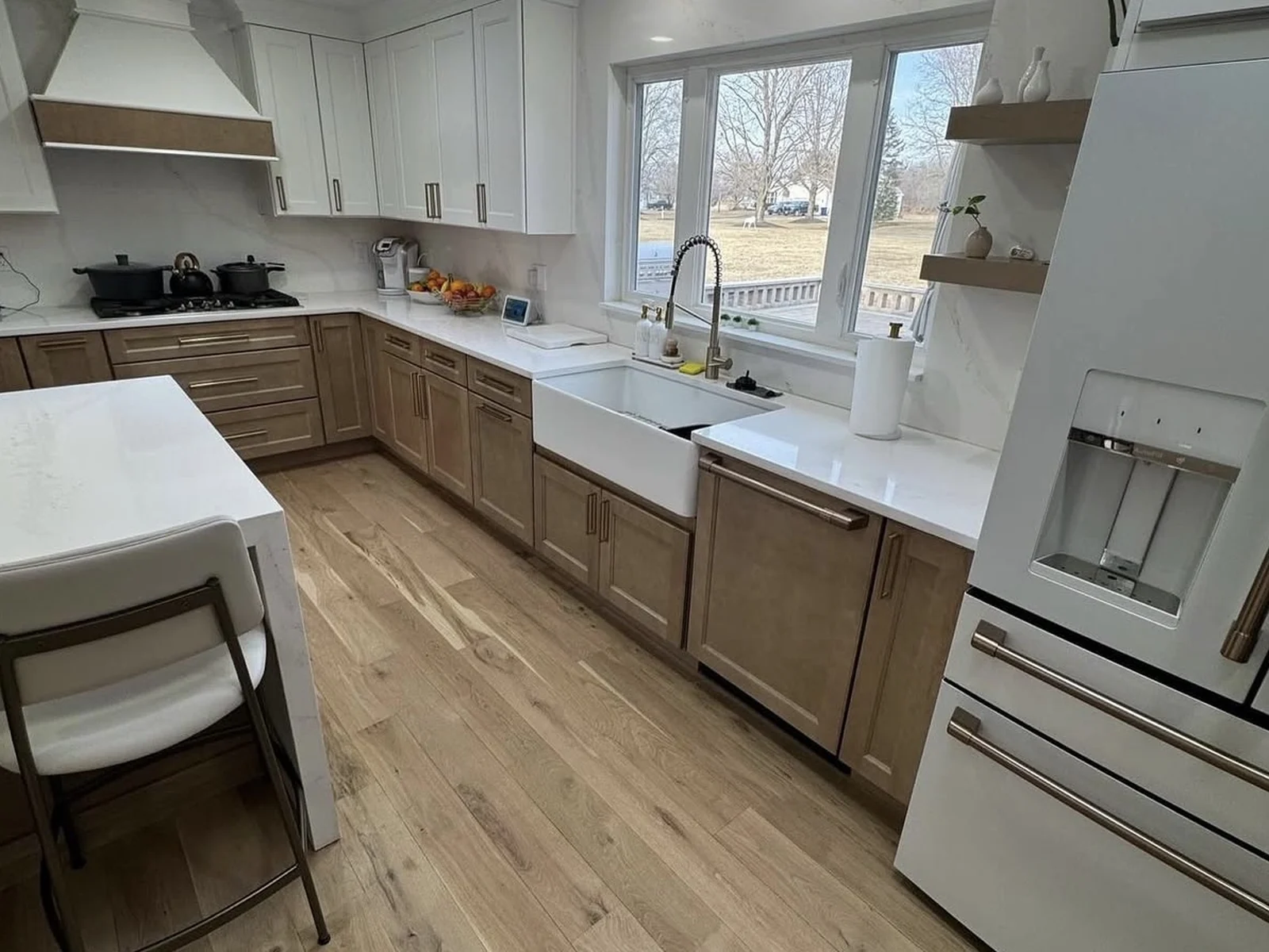 Two-tone kitchen cabinets — white upper doors above wood-toned lower doors and drawer fronts — in a Yukon, Oklahoma kitchen remodeled by MASB Construction