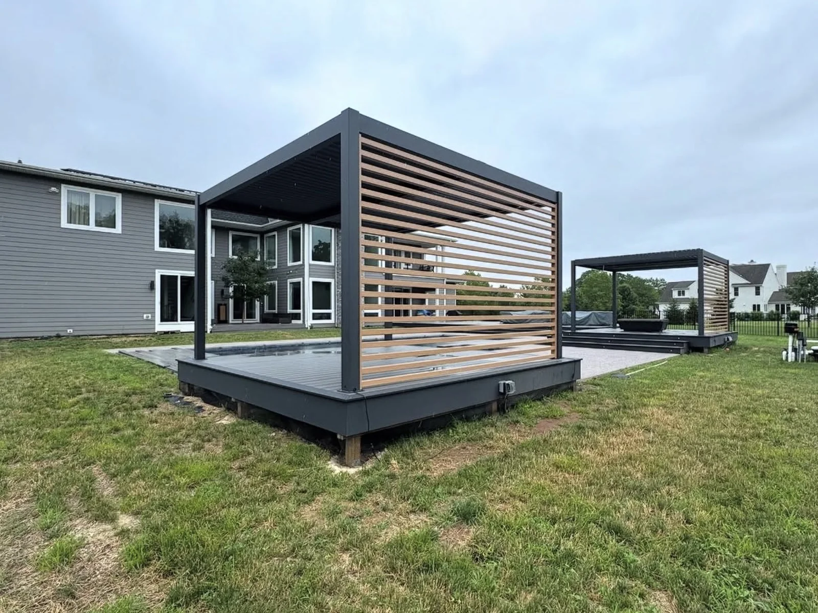 Elevated composite deck and pergola in Norman by MASB Construction